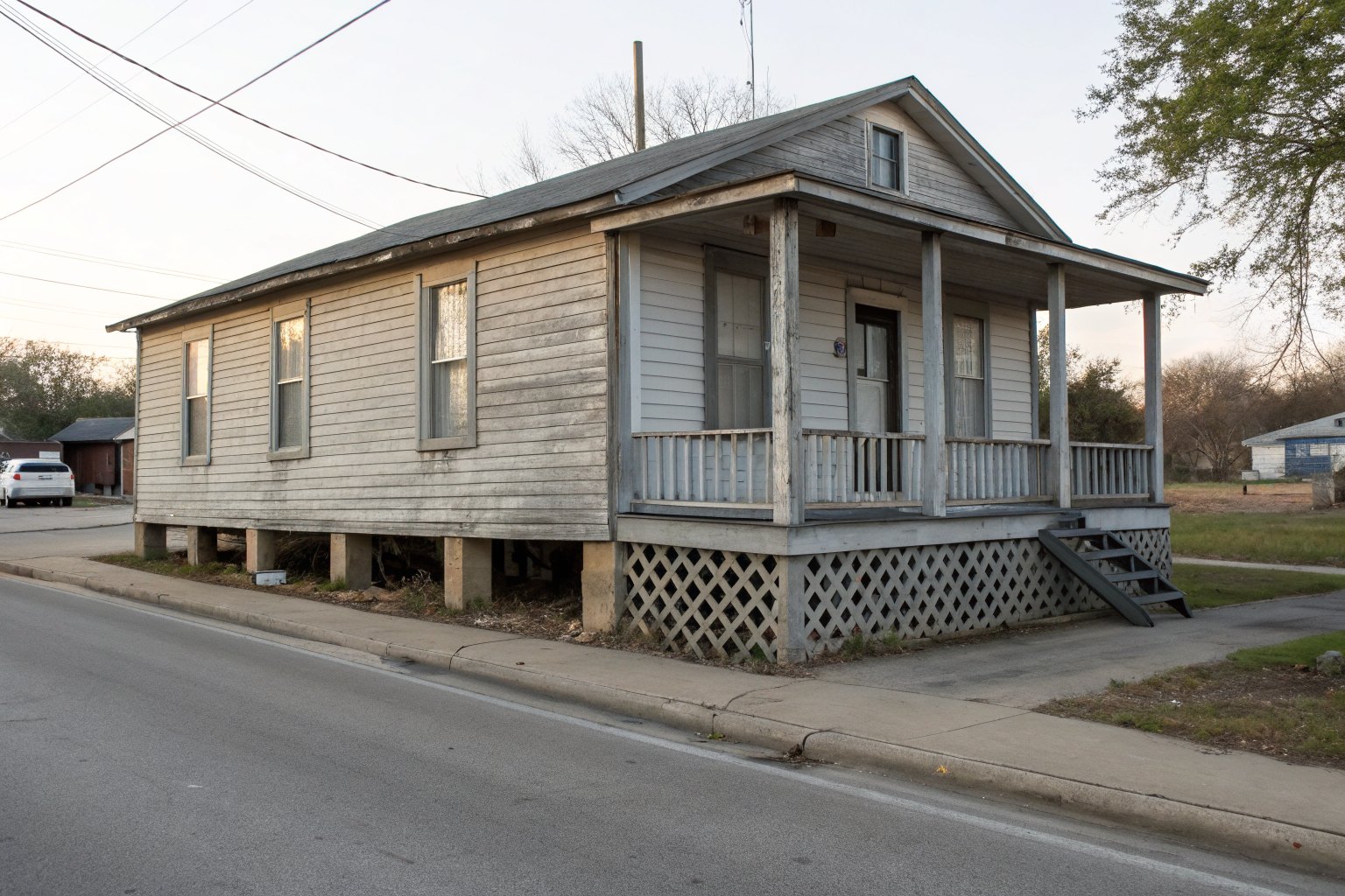 Older wood house raised on piers with lattice skirting